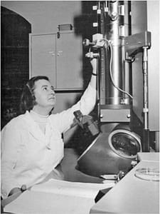Photograph of June Almeida in the 1960s using a Philips EM300 electron microscope. Credit - Joyce Almeida.