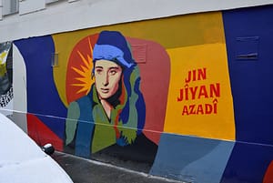 A mural in Vienna shows a Kurdish woman and the slogan of "Woman, Life, Freedom" (in Kurdish) - Herzi Pinki